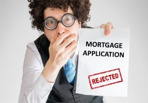 Disappointed man showing paper with denied mortgage application