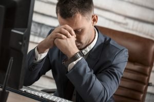 Businessman experiencing sudden headache while working