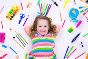 Child smiling with her preschool educational supplies