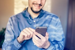 a man checking his social media accounts using a smartphone a man checking his social media accounts using a smartphone