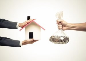 a man handing a bag of coins in exhcange of a wooden home, mortgage concept