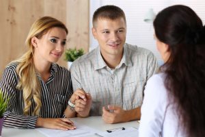 Couple discussing with real estate agent Couple discussing with real estate agent